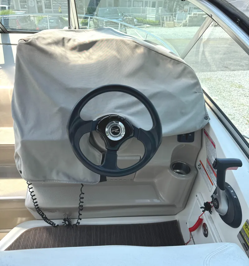 Slide: The Image of Steering wheel of a 2008 Sea Ray 240 Sundancer boat, covered and docked. - 11