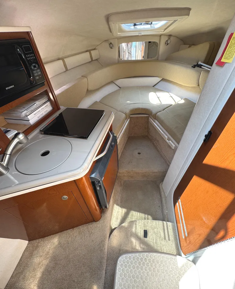Slide: The Image of 2008 Sea Ray 240 Sundancer cabin interior with kitchenette and seating area. - 17