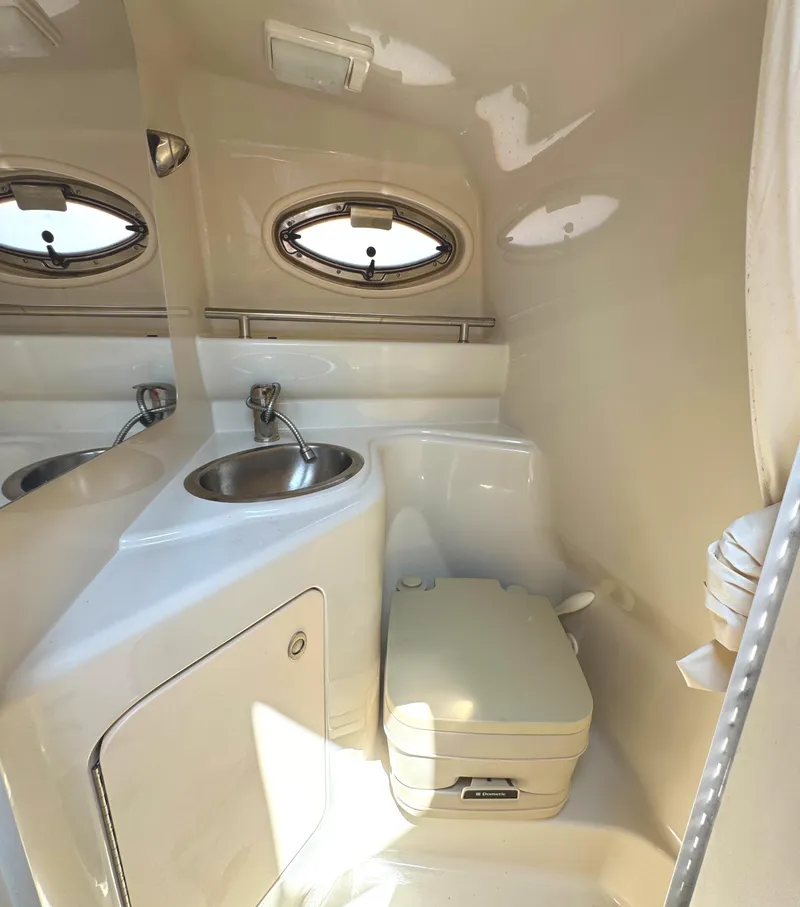 Slide: The Image of 2008 Sea Ray 240 Sundancer boat bathroom with sink and portable toilet. - 21