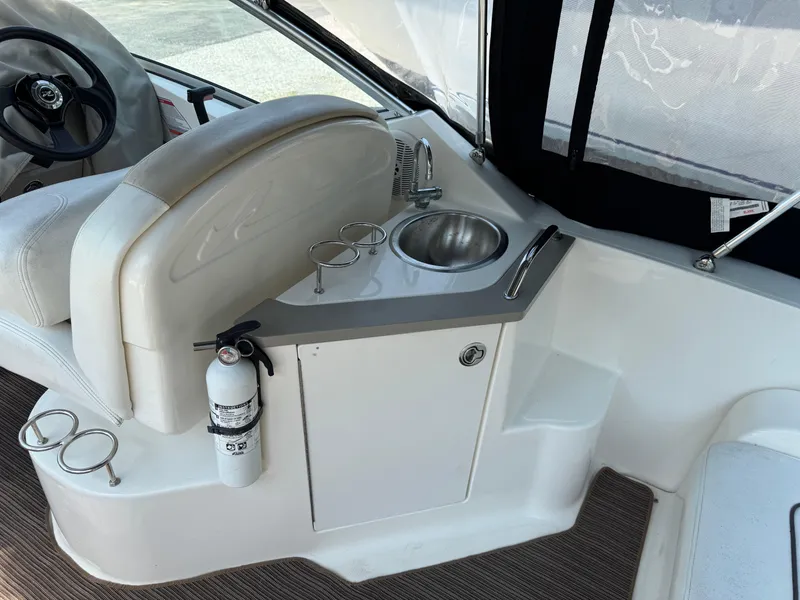 Slide: The Image of 2008 Sea Ray 240 Sundancer cockpit with sink, steering wheel, and fire extinguisher. - 7