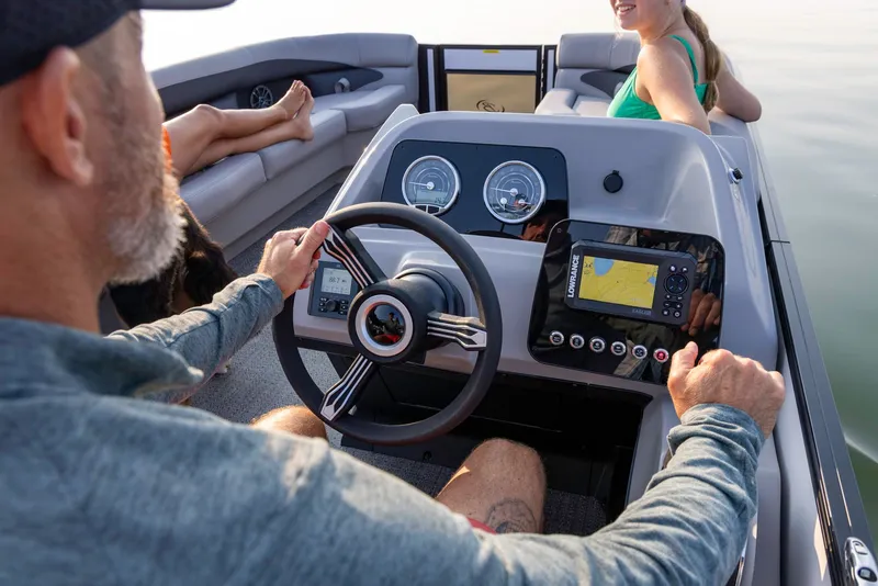 Slide: The Image of Man steering 2026 Barletta Aria 22 UC boat on calm water. - 3