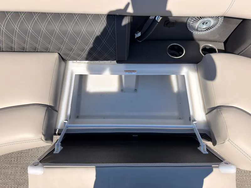 Slide: The Image of The image shows an open storage compartment on a boat with cushioned seats and cup holders. - 18