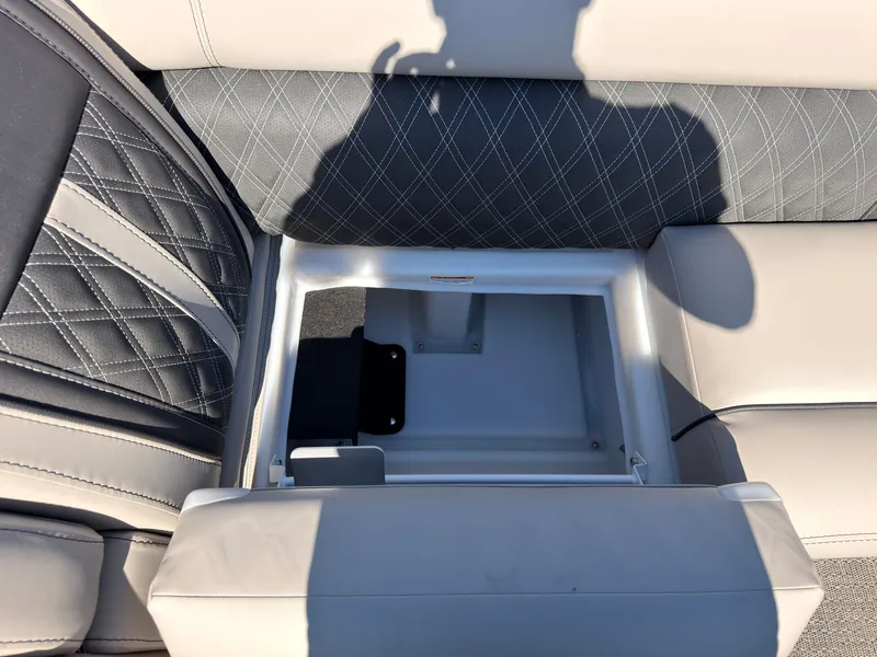 Slide: The Image of An open storage compartment in a boat seat with gray and white upholstery. - 20