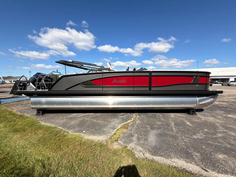 The Image of A sleek 2026 Barletta Lusso 25 U pontoon boat is parked on a lot under a blue sky. - 0
