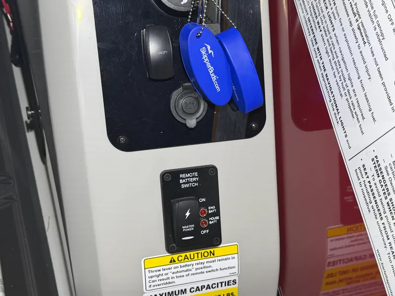 Slide: The Image of Close-up of a remote battery switch with warning labels and blue keys on a Barletta Lusso 23 QCSS. - 27