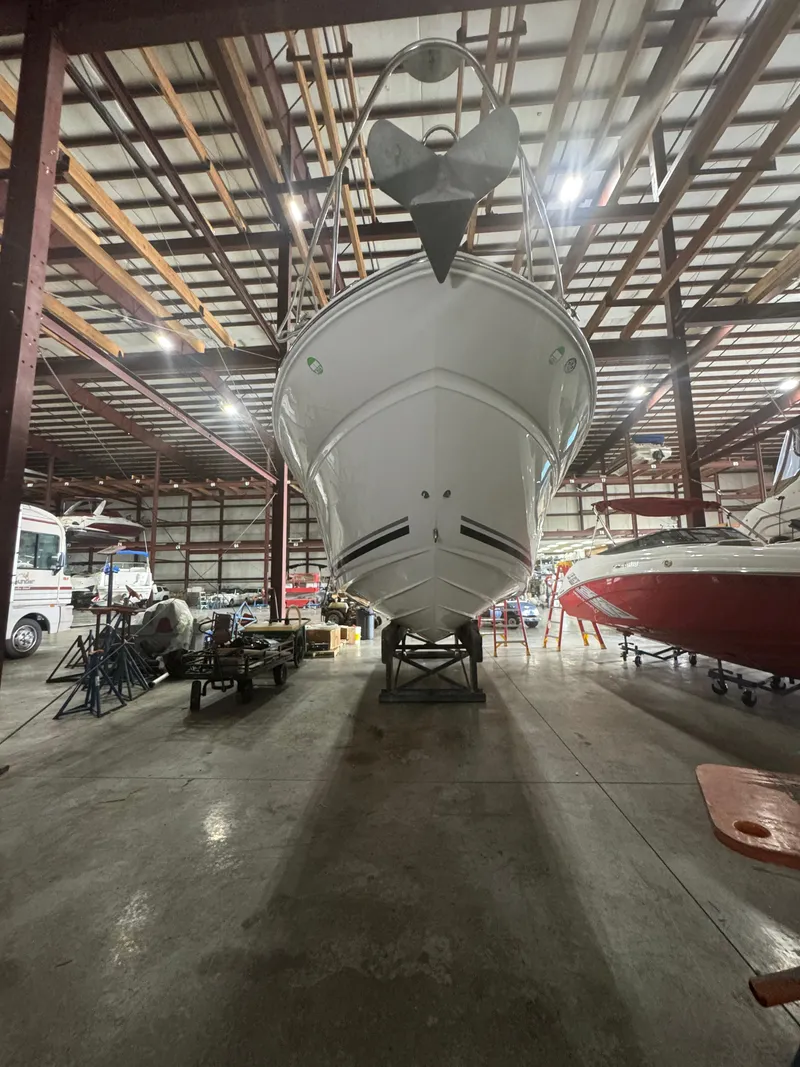 Slide: The Image of 2004 Sea Ray 260 Sundancer boat stored indoors in a spacious warehouse. - 1