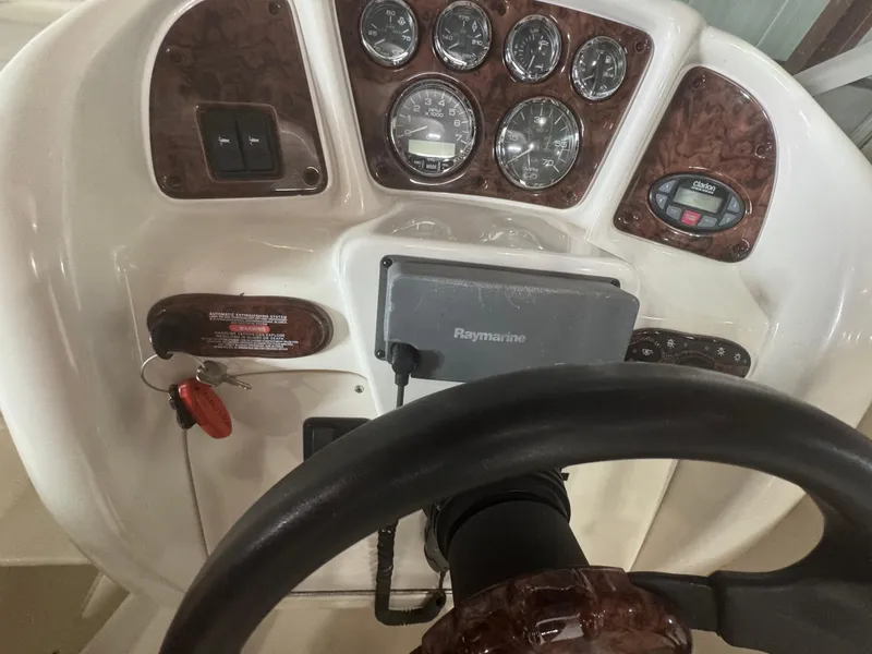 Slide: The Image of 2004 Sea Ray 260 Sundancer dashboard with gauges, steering wheel, and Raymarine navigation system. - 11