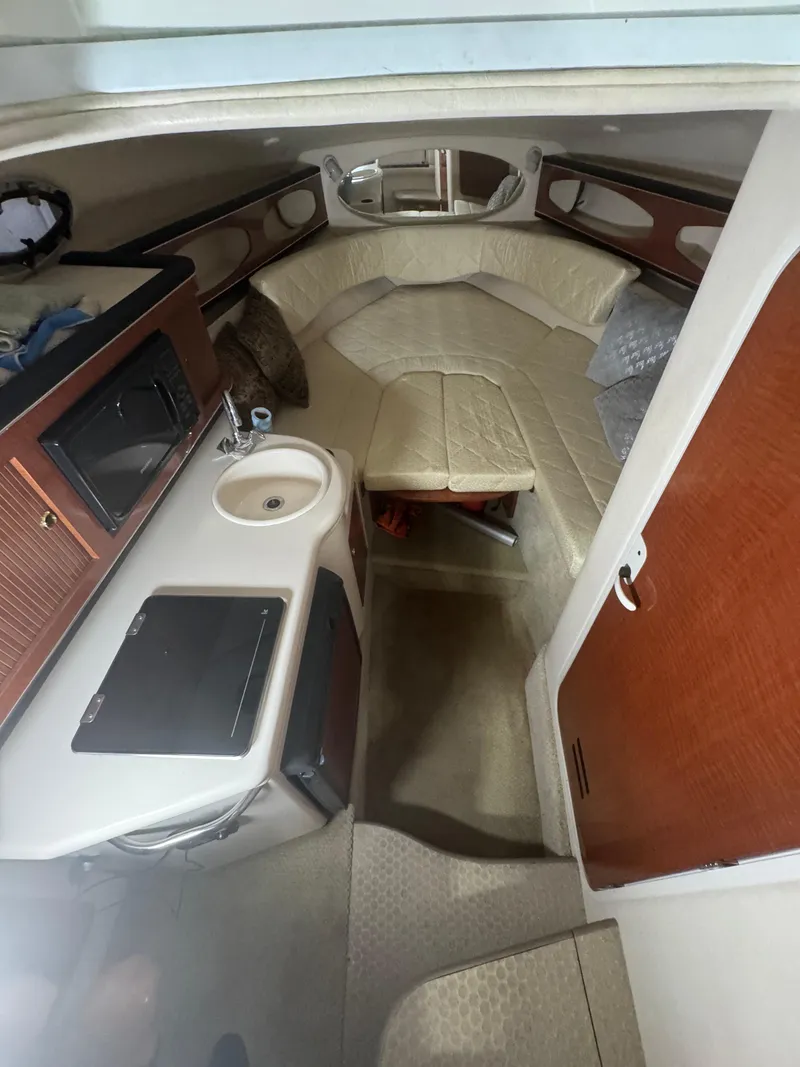 Slide: The Image of 2004 Sea Ray 260 Sundancer cabin interior with kitchenette and seating area. - 14