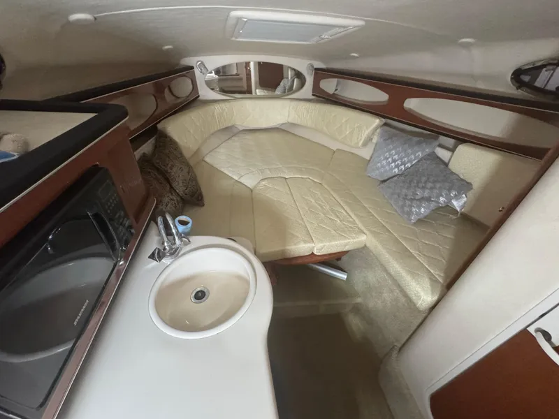 Slide: The Image of 2004 Sea Ray 260 Sundancer cabin interior with kitchenette and seating area. - 15