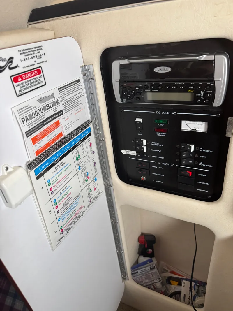 Slide: The Image of Control panel inside a 2004 Sea Ray 260 Sundancer boat, featuring electrical switches and a stereo system. - 17
