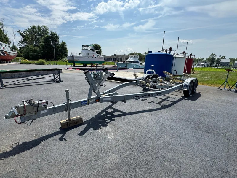 Slide: The Image of Boat trailer on asphalt, suitable for 2004 Sea Ray 260 Sundancer, with boats in background. - 31