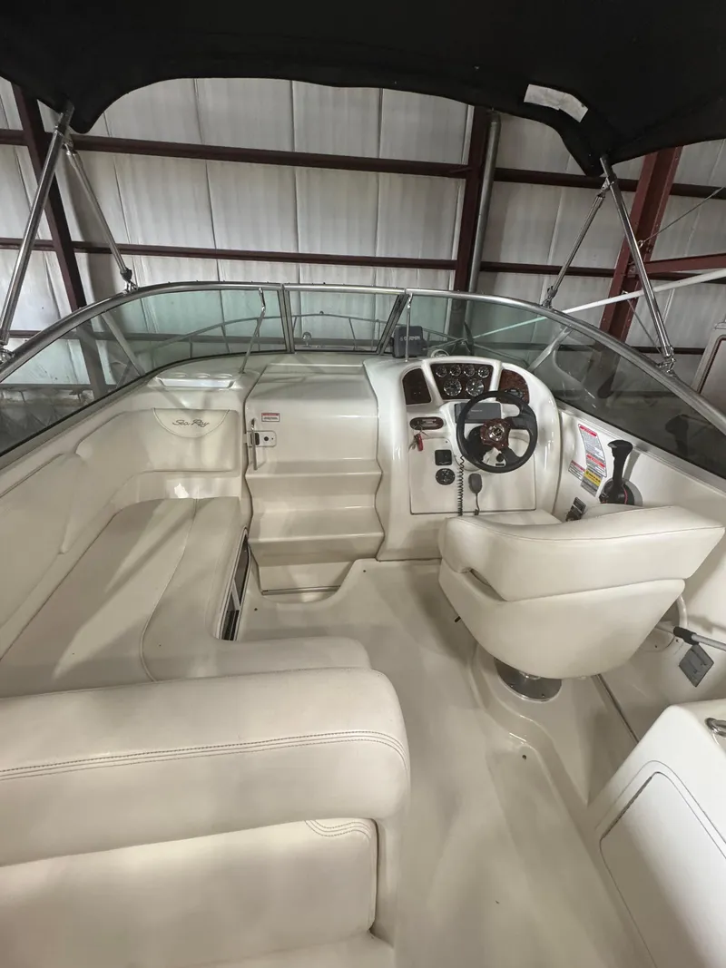 Slide: The Image of 2004 Sea Ray 260 Sundancer boat interior with steering wheel and seating area. - 4
