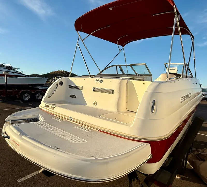 Slide: The Image of 2013 Ebbtide 2500 SS Fun Cruiser DC boat with red canopy, docked outdoors. - 3