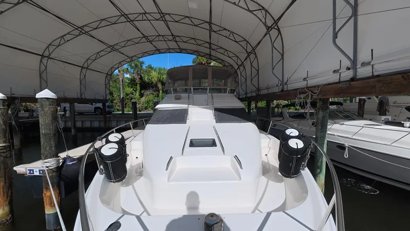 Slide: The Image of 2001 Sea Ray 450 Express Bridge yacht docked under a canopy. - 10