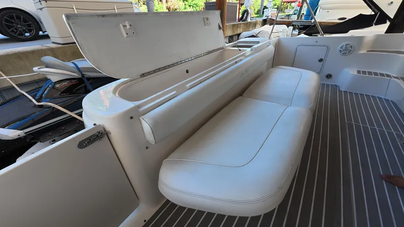 Slide: The Image of 2001 Sea Ray 450 Express Bridge interior with white seating and storage compartment. - 23