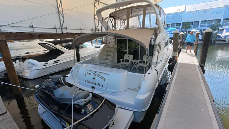 Slide: The Image of 2001 Sea Ray 450 Express Bridge docked with jet ski, marina setting. - 24