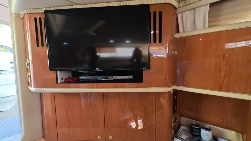Slide: The Image of Interior of 2001 Sea Ray 450 Express Bridge with mounted TV and wooden cabinetry. - 27