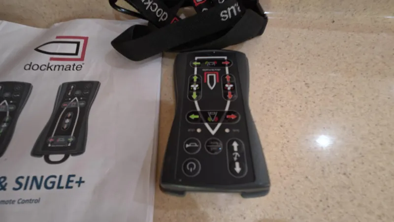 Slide: The Image of Dockmate remote control on a countertop, next to a manual, for Sea Ray 450 Express Bridge. - 5
