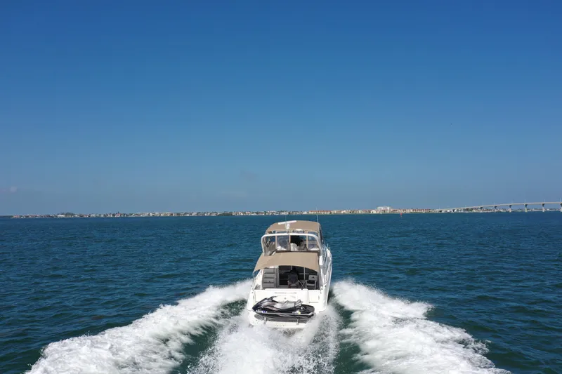 Slide: The Image of 2001 Sea Ray 450 Express Bridge cruising on open water under clear blue sky. - 9