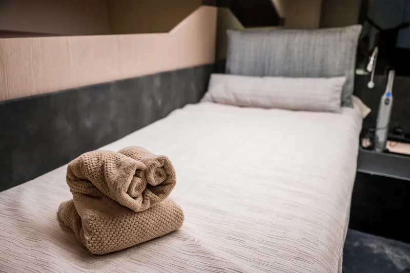 Slide: The Image of Luxurious Santasevera52 2026 yacht cabin with neatly folded towels on bed. - 11