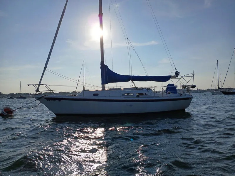 Slide: The Image of 1988 Ericson 30+ sailboat on water at sunset, with sails down. - 1