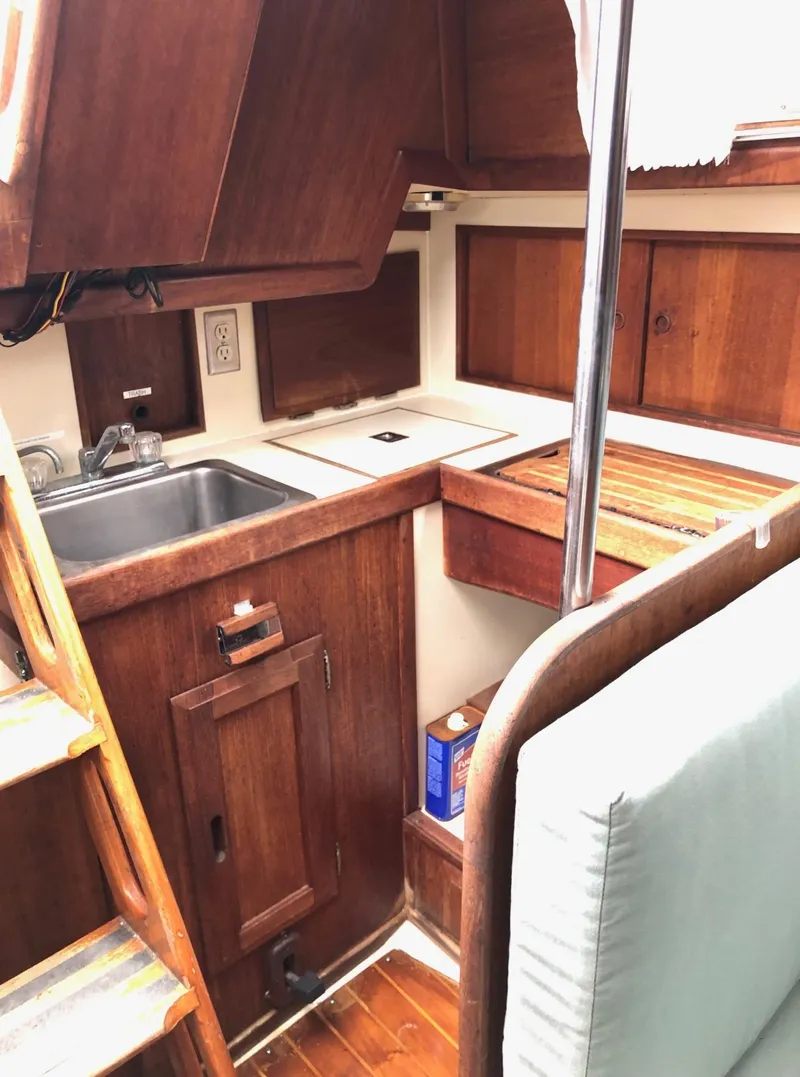 Slide: The Image of 1988 Ericson 30+ sailboat interior with wooden cabinetry and compact kitchen area. - 13