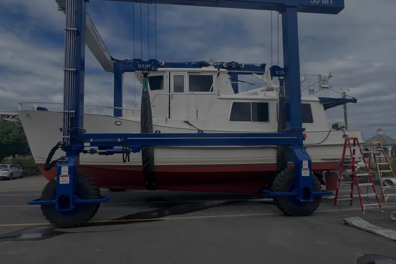Slide: The Image of 1998 Cherubini Independence boat on a lift at a marina, under cloudy skies. - 103