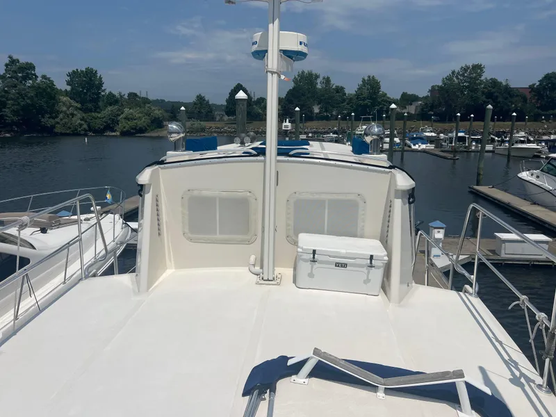 Slide: The Image of 1998 Cherubini Independence yacht docked at marina, featuring spacious deck and cooler. - 12
