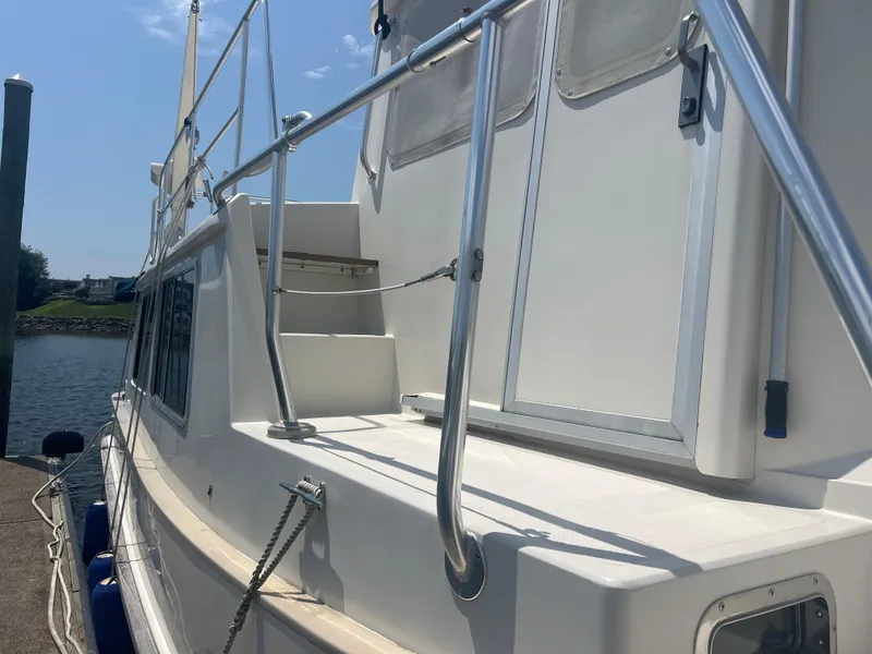 Slide: The Image of 1998 Cherubini Independence boat docked, featuring sleek white exterior and stainless steel railings. - 16