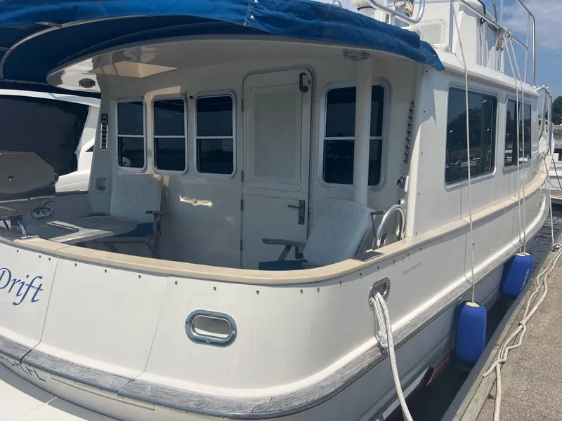 Slide: The Image of 1998 Cherubini Independence yacht docked, featuring a spacious deck and blue canopy. - 24