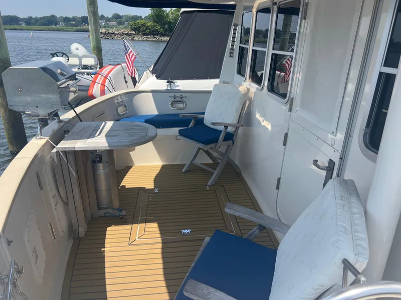 Slide: The Image of 1998 Cherubini Independence yacht deck with seating, table, and grill by the water. - 26