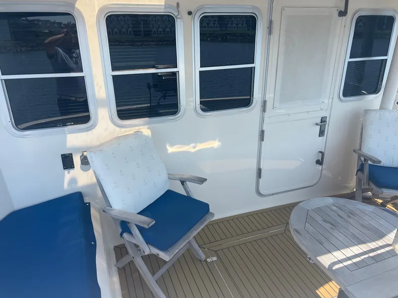 Slide: The Image of Deck seating area on 1998 Cherubini Independence yacht with blue cushions and wooden table. - 27