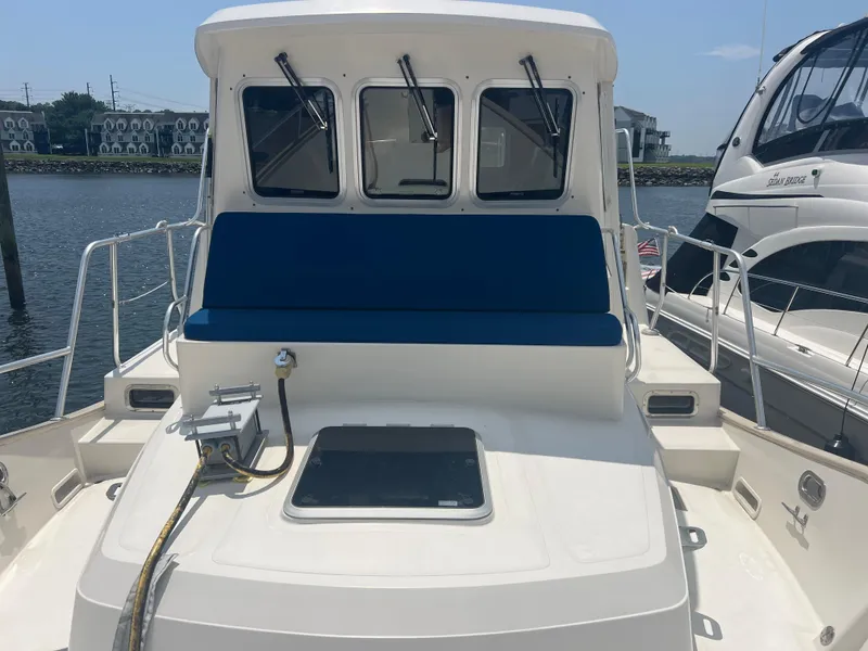 Slide: The Image of 1998 Cherubini Independence boat with blue seating, docked near waterfront buildings. - 3