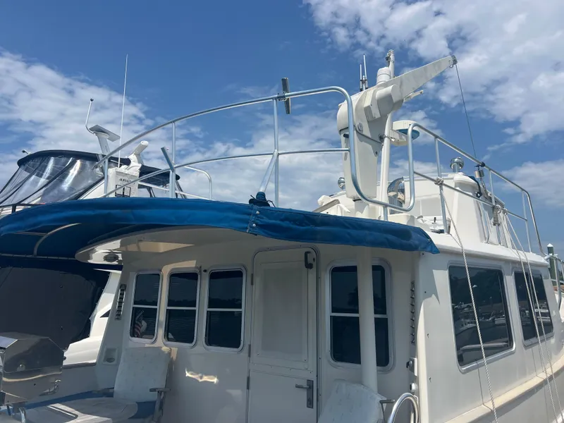Slide: The Image of Cherubini Independence 1998 yacht with blue canopy under a partly cloudy sky. - 35
