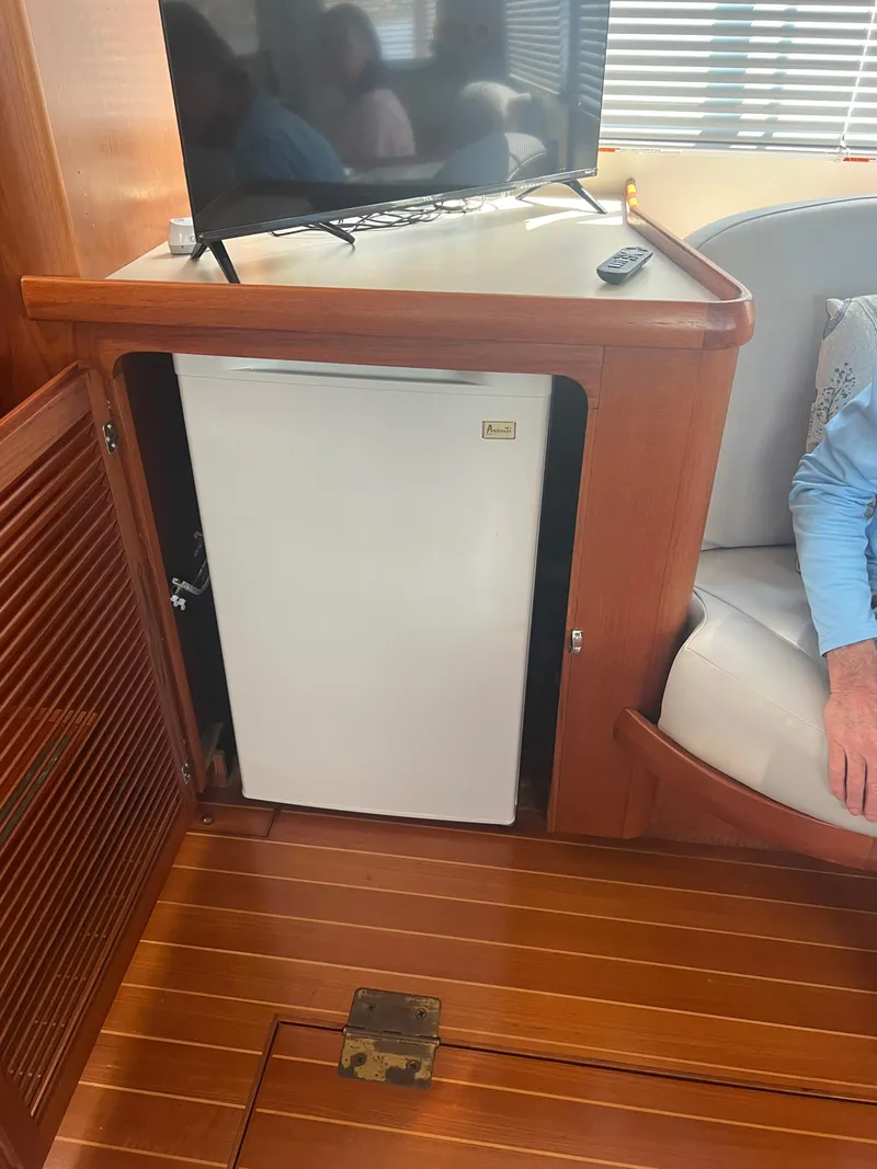 Slide: The Image of Interior of 1998 Cherubini Independence with mini fridge and TV on wooden cabinetry. - 44