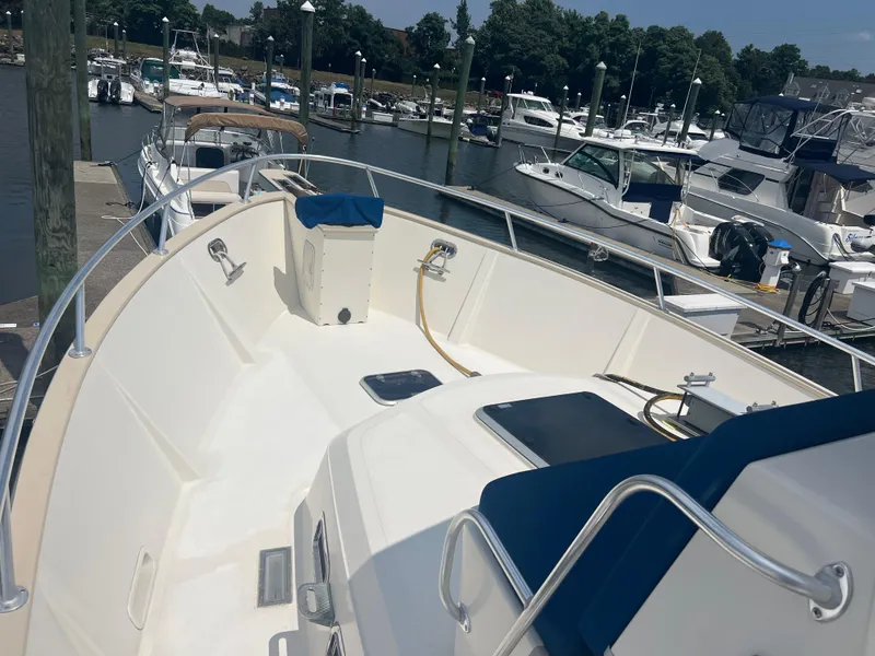 Slide: The Image of 1998 Cherubini Independence boat docked at marina, featuring spacious deck and railing. - 6