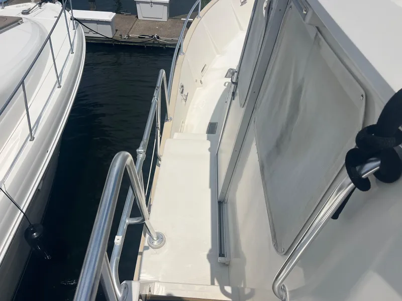 Slide: The Image of 1998 Cherubini Independence yacht deck with railing, docked beside another boat. - 8