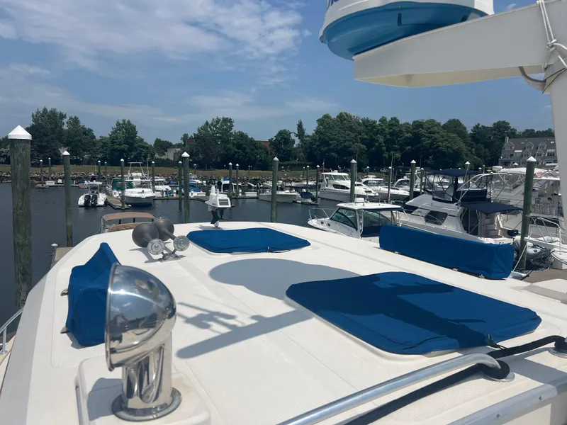 Slide: The Image of 1998 Cherubini Independence yacht docked at marina, featuring blue cushions and clear sky. - 9
