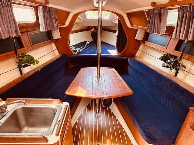 Slide: The Image of Interior of a 1986 Pearson 28 sailboat with blue seating and wooden accents. - 10