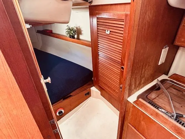 Slide: The Image of Cozy cabin interior of 1986 Pearson 28 sailboat with wooden finishes and compact sleeping area. - 13