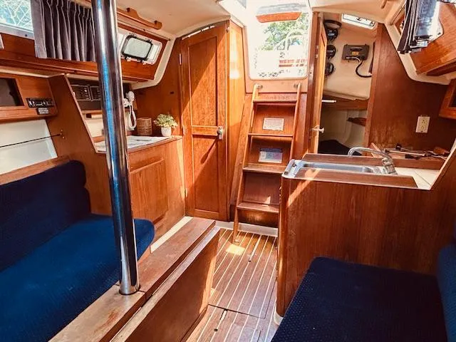Slide: The Image of Interior of 1986 Pearson 28 sailboat with wood finish and blue seating. - 15