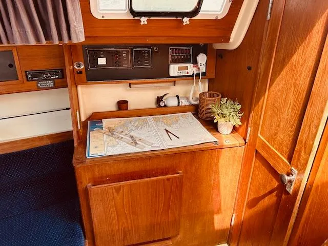 Slide: The Image of Navigation station inside a 1986 Pearson 28 sailboat with charts and equipment. - 16