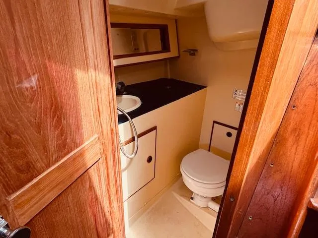 Slide: The Image of 1986 Pearson 28 sailboat bathroom with wooden door, sink, and toilet. - 18