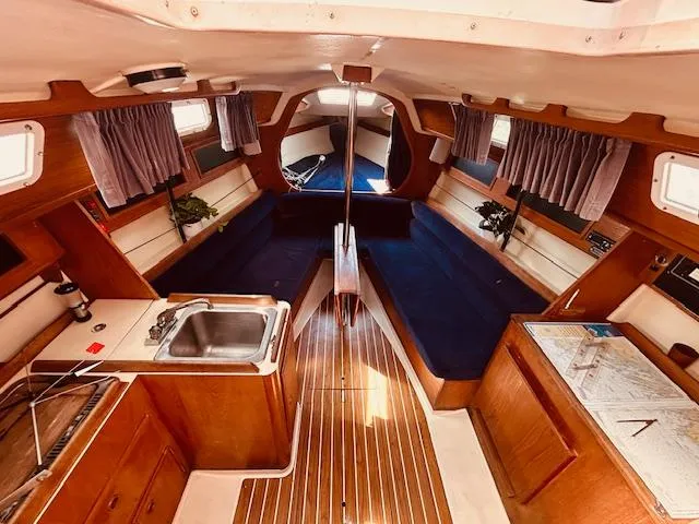 Slide: The Image of Interior of a 1986 Pearson 28 sailboat with wood finish and blue seating. - 19