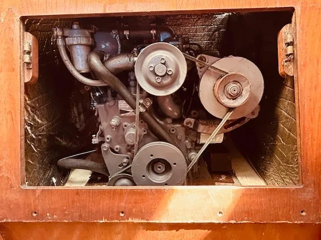 Slide: The Image of Engine compartment of a 1986 Pearson 28 sailboat, showcasing mechanical components and belts. - 23