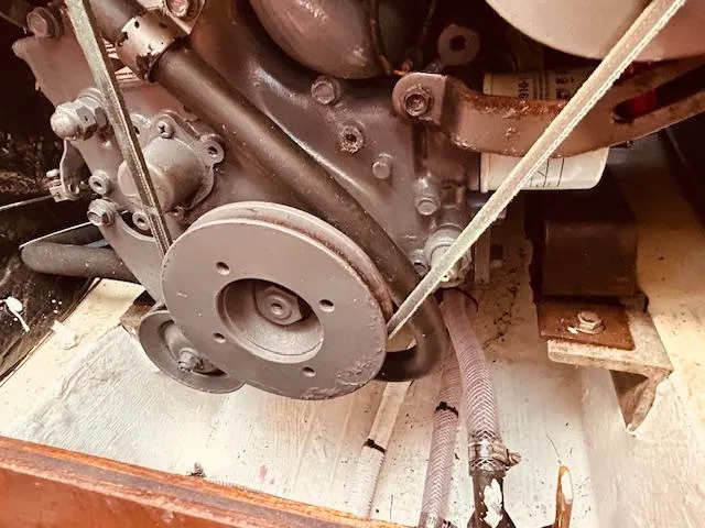 Slide: The Image of Engine compartment of a 1986 Pearson 28 sailboat, showing mechanical components and hoses. - 25