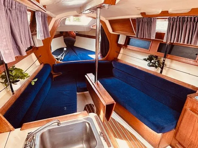 Slide: The Image of Interior of a 1986 Pearson 28 sailboat with blue seating and wooden accents. - 8