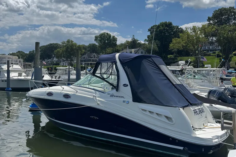 The Image of 2005 Sea Ray 260 Sundancer boat docked at a marina under a partly cloudy sky. - 1