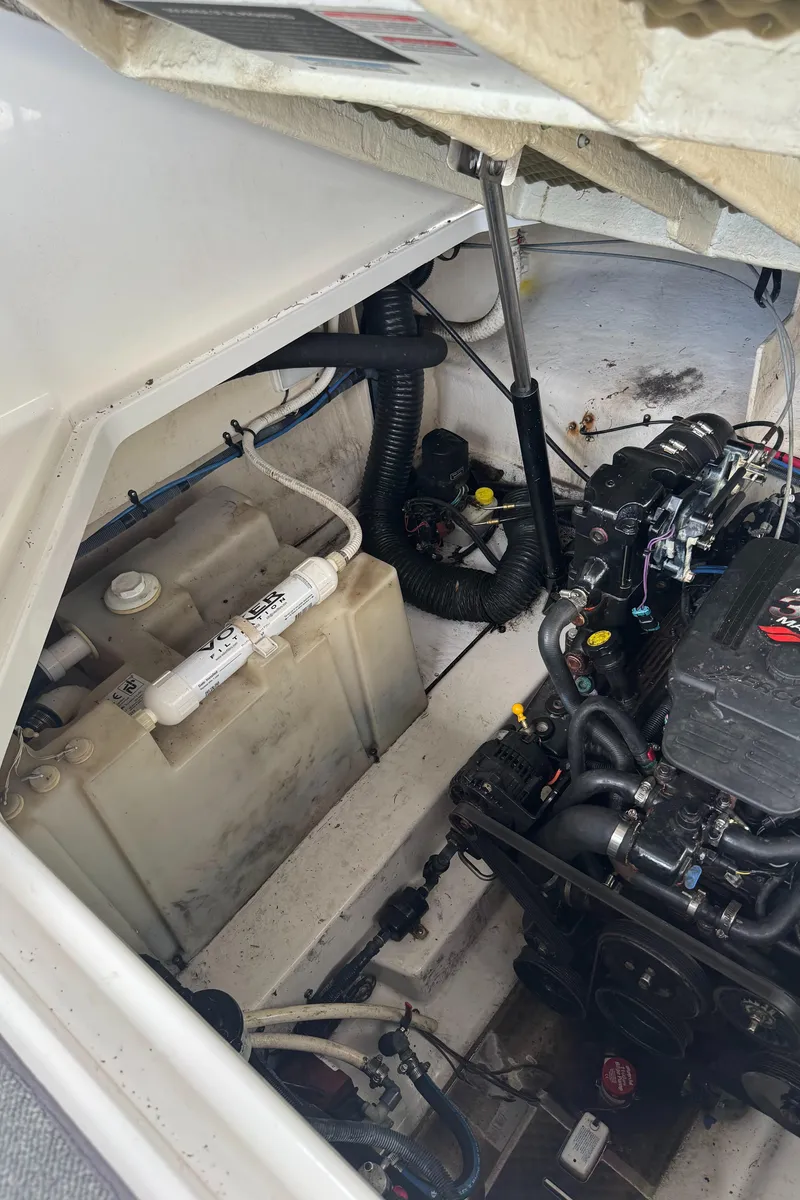 Slide: The Image of Engine compartment of a 2005 Sea Ray 260 Sundancer boat, showing mechanical components and storage. - 18