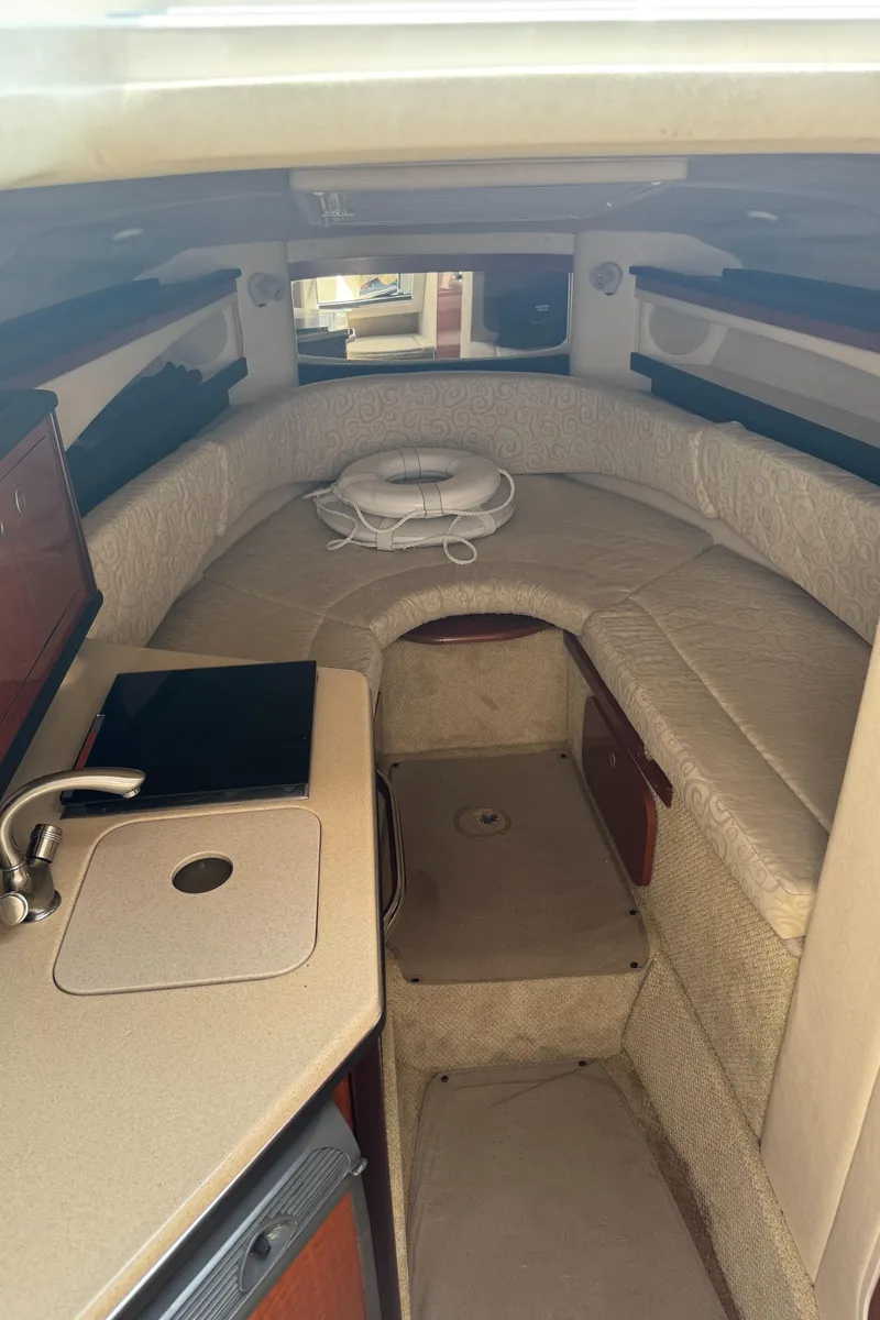 Slide: The Image of Interior of a 2005 Sea Ray 260 Sundancer boat with cozy seating and compact kitchenette. - 24